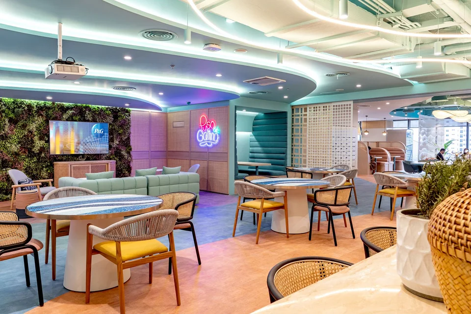 Bàn nhóm, booth và bảng màu tím xanh giàu năng lượng. · Procter & Gamble Offices – Manila
