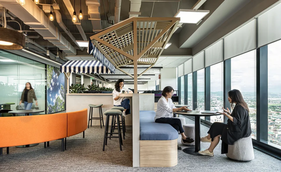 Không gian làm việc chung với nhiều kiểu chỗ ngồi, bàn cửa sổ và người sử dụng.